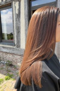 Cheveux longs lisses colorés en cuivré brillant, coloration réalisée à domicile